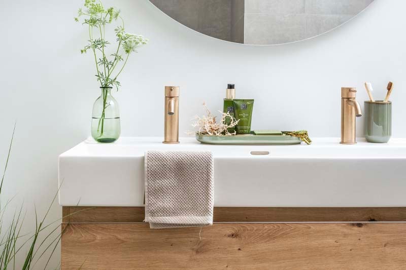 Une salle de bain luxueuse avec des plantes fraîches et une expérience olfactive subtile qui crée une atmosphère calme et raffinée.