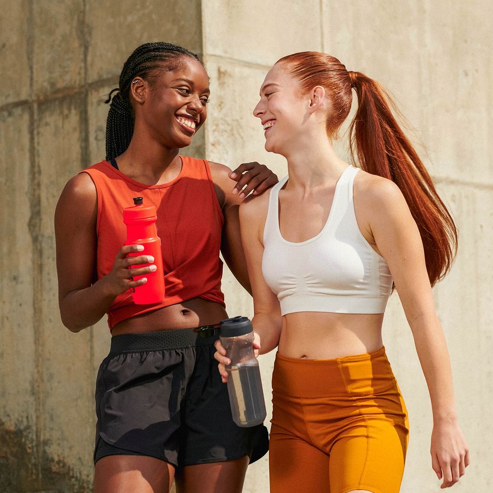 Two gym friends enjoying the benefits of scent marketing in their workout space.