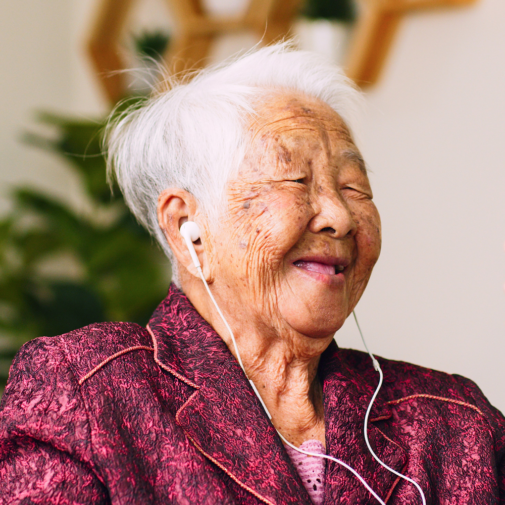 Elderly woman enjoying music and scent experience healthcare