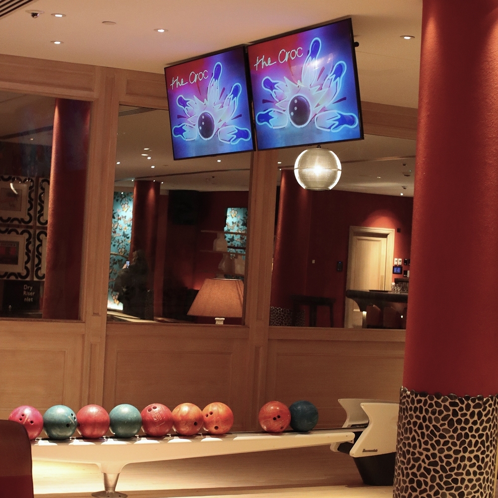 Bowling alley with ambient lighting and screens, enhanced by scent experience