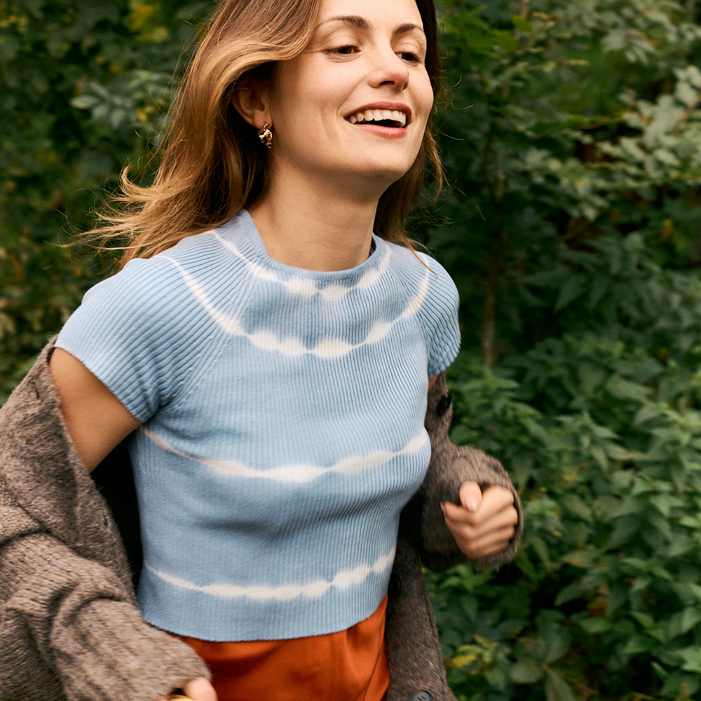 Smiling woman enjoying fresh scents and uplifting scent experience.