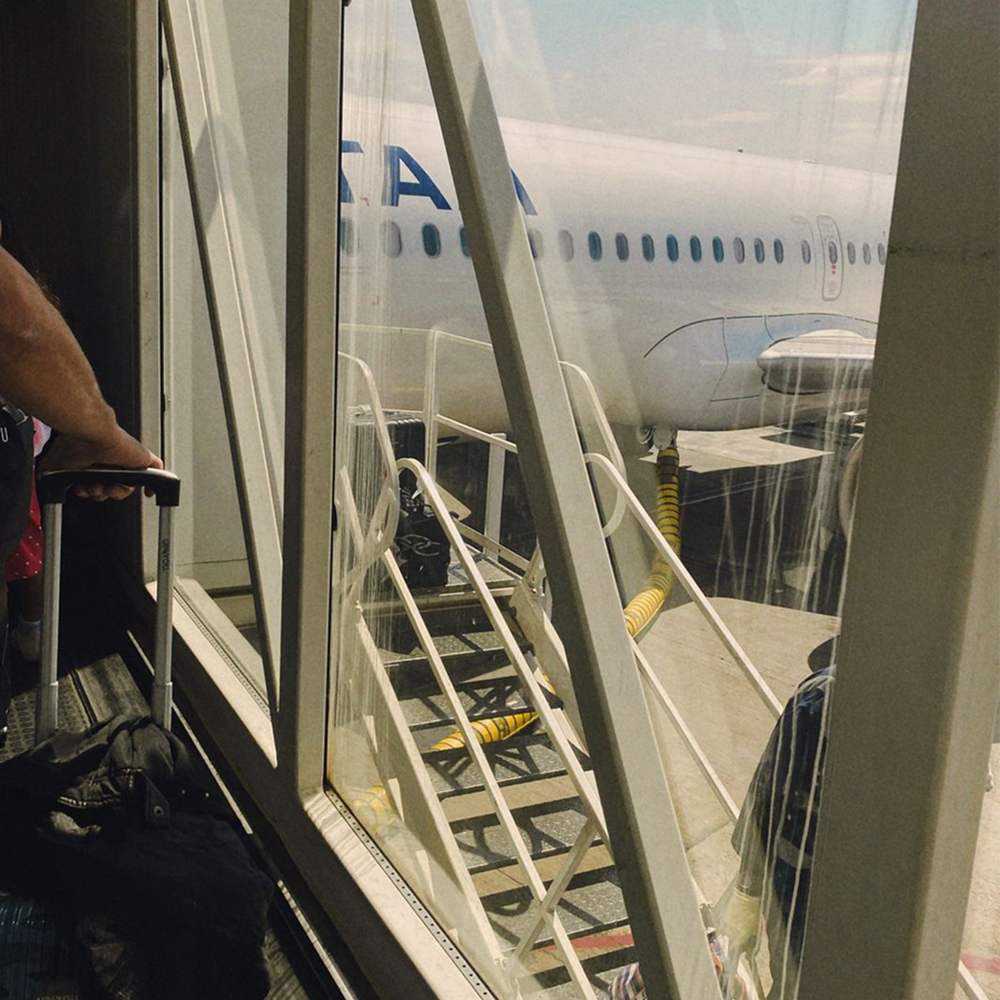 Traveler with suitcase heading to airplane in airport with scent experience.
